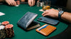 Markore Niva Zoj, Markore Navy Indigo Blue wallet and Markore Shell Frame phone case are sitting on a poker table, person is wearing watch with Hour Line Universal watch strap.