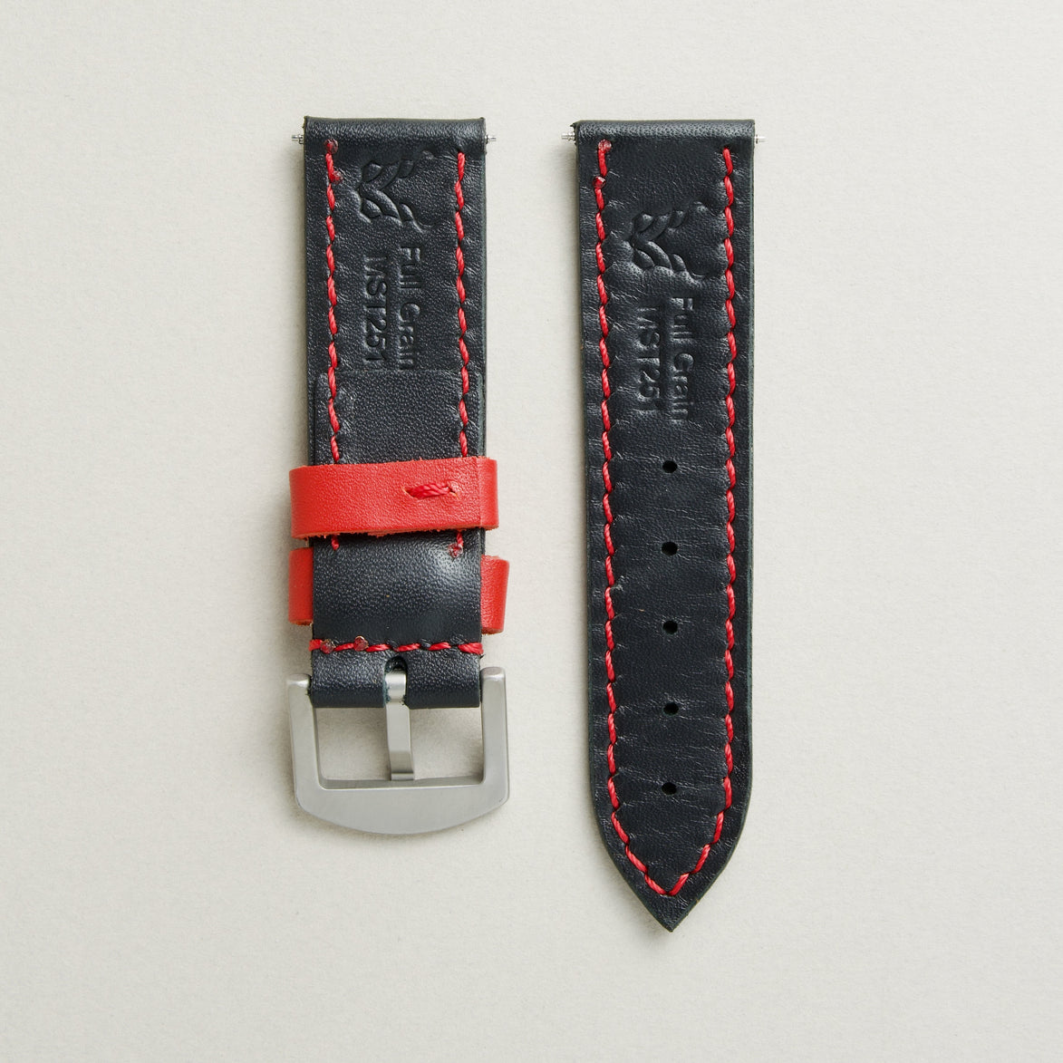 Back view of midnight black leather strap with stainless steel buckle, showing red stitching and matching loops, embossed logo, and serial number. Markore Hour Line.