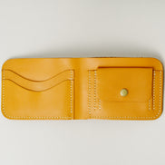 Inside view of full grain leather bifold wallet in amber, featuring ivory handmade stitching, a coin pocket with brass press stud and card slots. Markore Hunza Fold.