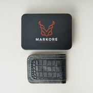 Back view of obsidian black croc-embossed full-grain leather bifold wallet featuring ivory handmade stitching and a black Markore branded box. Markore Indus Sultan