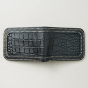 Outside view of obsidian black croc-embossed full-grain leather bifold wallet featuring ivory handmade stitching. Markore Indus Sultan