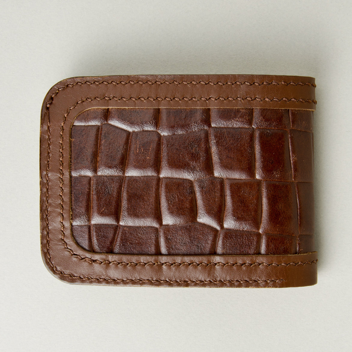 Back view of espresso brown croc-embossed full-grain leather bifold wallet featuring handmade stitching. Markore Indus Sultan