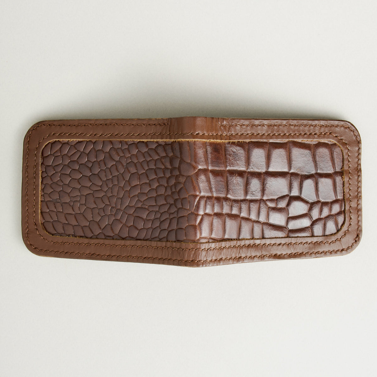 Outside view of espresso brown croc-embossed full-grain leather bifold wallet featuring handmade stitching. Markore Indus Sultan
