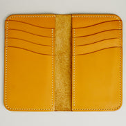 Inside view of vertical full-grain leather bifold wallet in amber, with cards lots and handmade stitching. Markore Karakoram II.