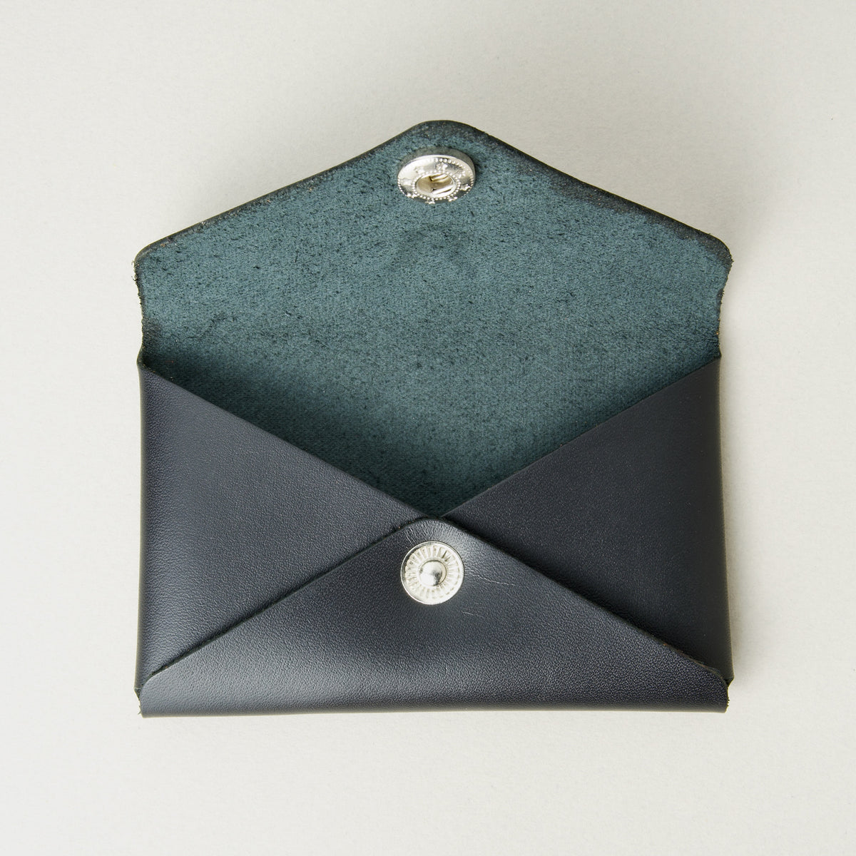 Front view of full grain leather envelope style wallet with open flap in midnight black with stainless steal press button. Markore Niva Seal.
