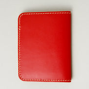 Back view of red full-grain leather wallet featuring ivory handmade stitching. Markore Ravi Fold.