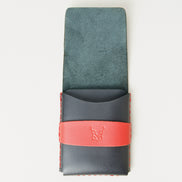Front view of midnight black full-grain leather flap wallet with open flap, featuring a red flap holder with embossed logo, and red handmade stitching. Markore Sutlej Vault.