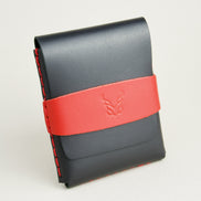 Side view of midnight black full-grain leather flap wallet featuring a red flap holder with embossed logo, and red handmade stitching. Markore Sutlej Vault.