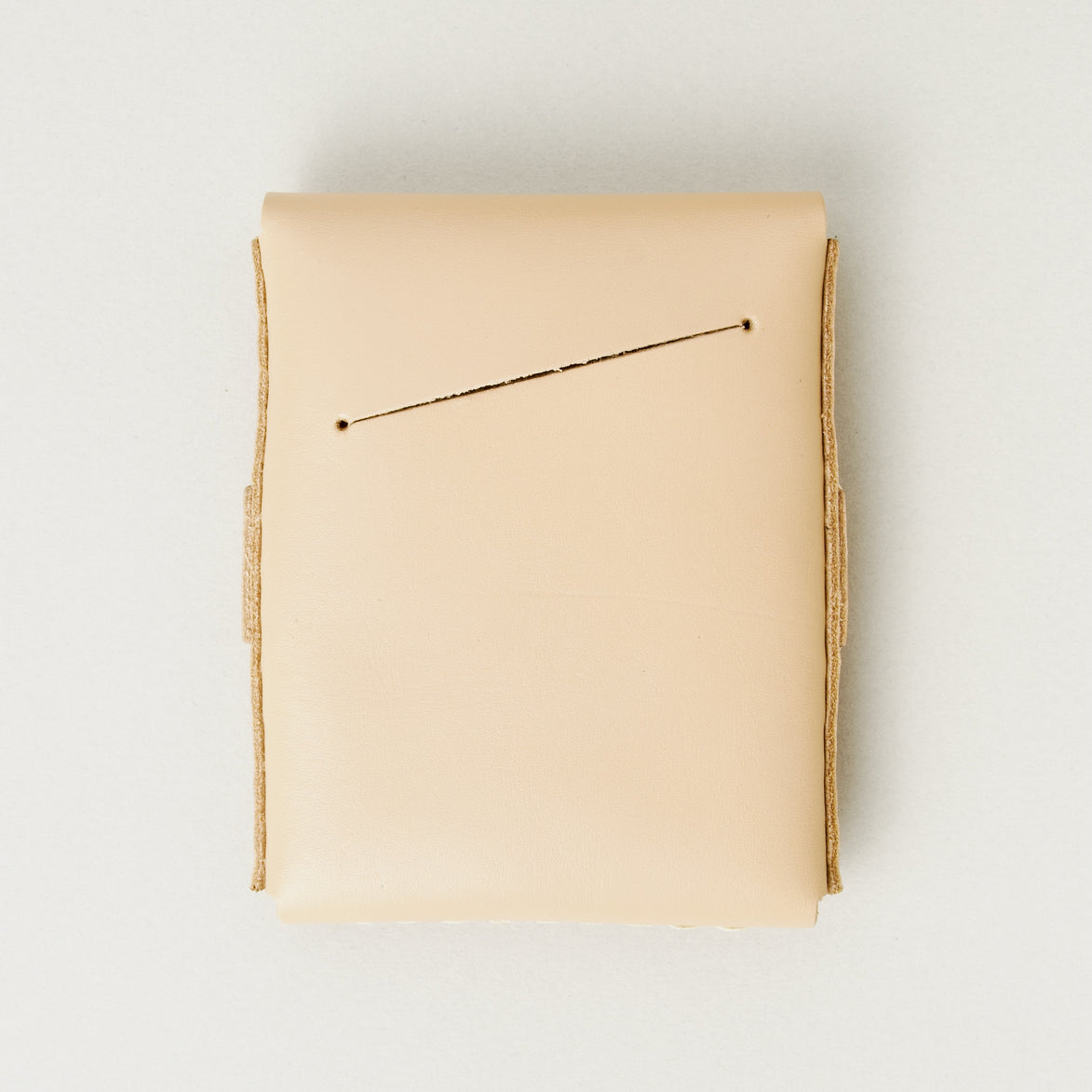 Back view of natural full-grain leather flap wallet featuring a card slot. Markore Sutlej Vault.