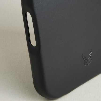 Detail of midnight black leather iphone 17 pro case featuring button cutout and embossed logo. Markore Shell Frame.