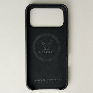 Inside view of midnight black leather iphone 17 pro case with full cutout showing velvet lining and brand logo. Markore Shell Frame.