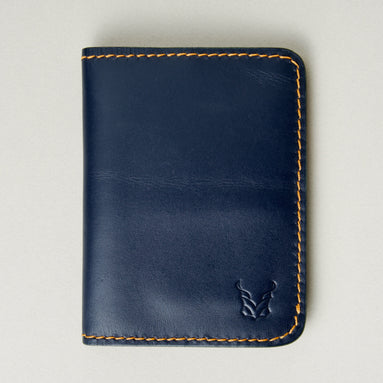 Front view of dark blue full-grain leather wallet featuring amber handmade stitching and embossed logo. Markore Ravi Edge.