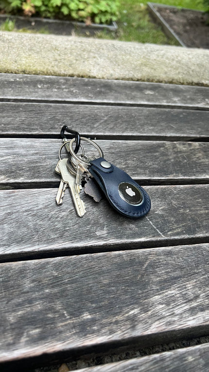 markore tagmate airtag holder Keychain with keys and a blue leather pouch on a wooden surface